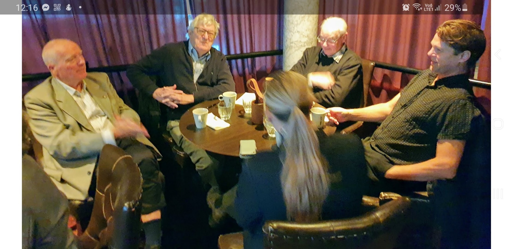 Rotarymedlemmar i samtal kring ett bord